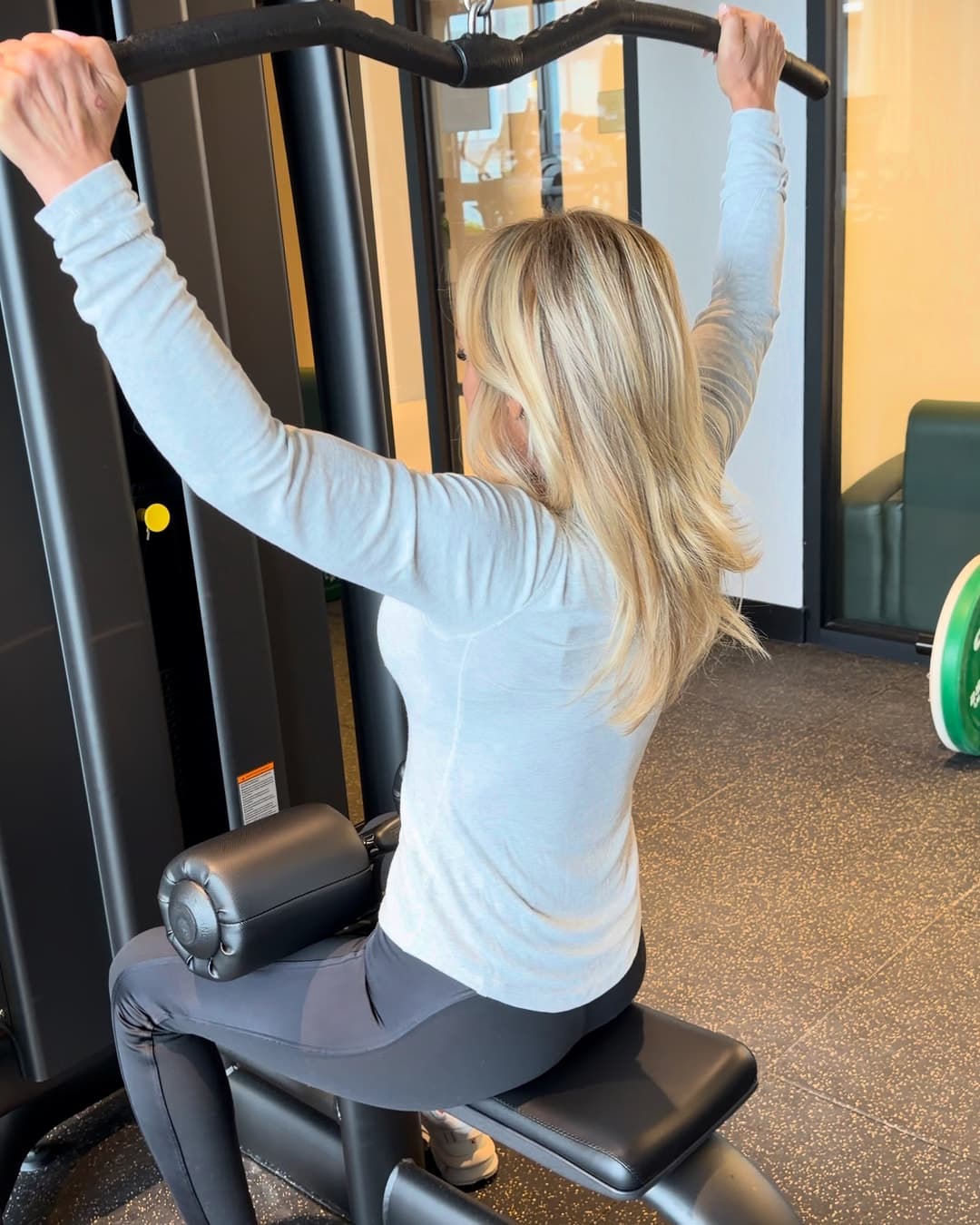 Une cliente effectue un tirage vertical dans la salle d'entraînement d'un immeuble en copropriété.