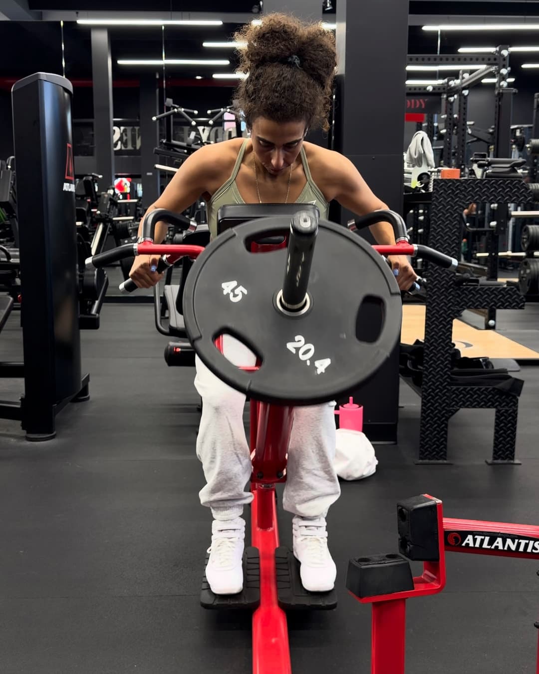 Gabrielle effectue un tirage à la barre en T dans une salle d'entraînement.